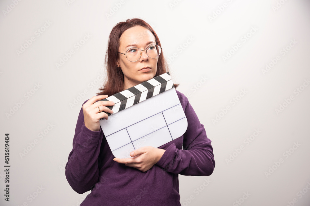 Young woman posing with a cinema tape on a white background Young woman posing with a cinema tape on a white background