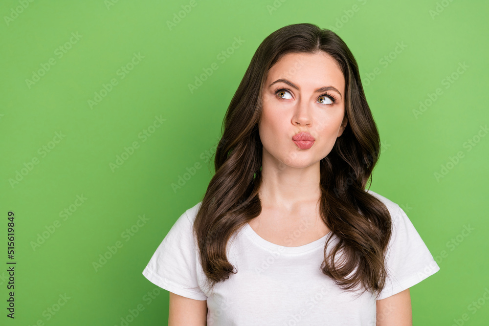 Photo of unsure dreamy woman dressed white t-shirt looking empty space isolated green color background Photo of unsure dreamy woman dressed white t-shirt looking empty space isolated green color background