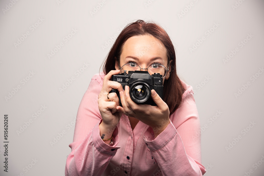 Woman taking a picture with camera on white background Woman taking a picture with camera on white background