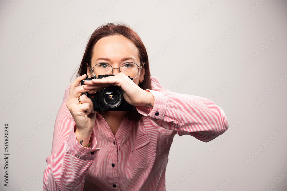 Woman taking a picture with camera on white background Woman taking a picture with camera on white background