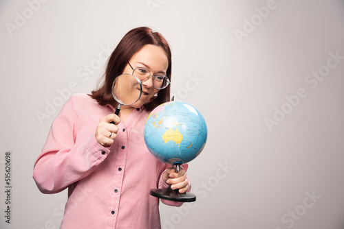 Portrait of woman holding a magnifying glass and Earth globe © azerbaijan-stockers