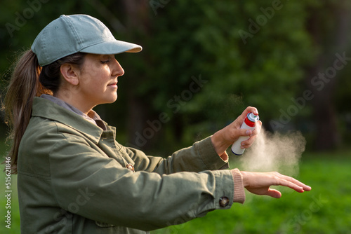 Fotografie health care, protection and people concept - woman spraying insect repellent or