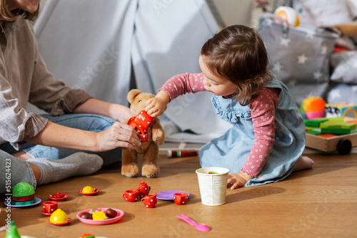 Photography family, leisure and people concept - happy mother and little baby daughter playi