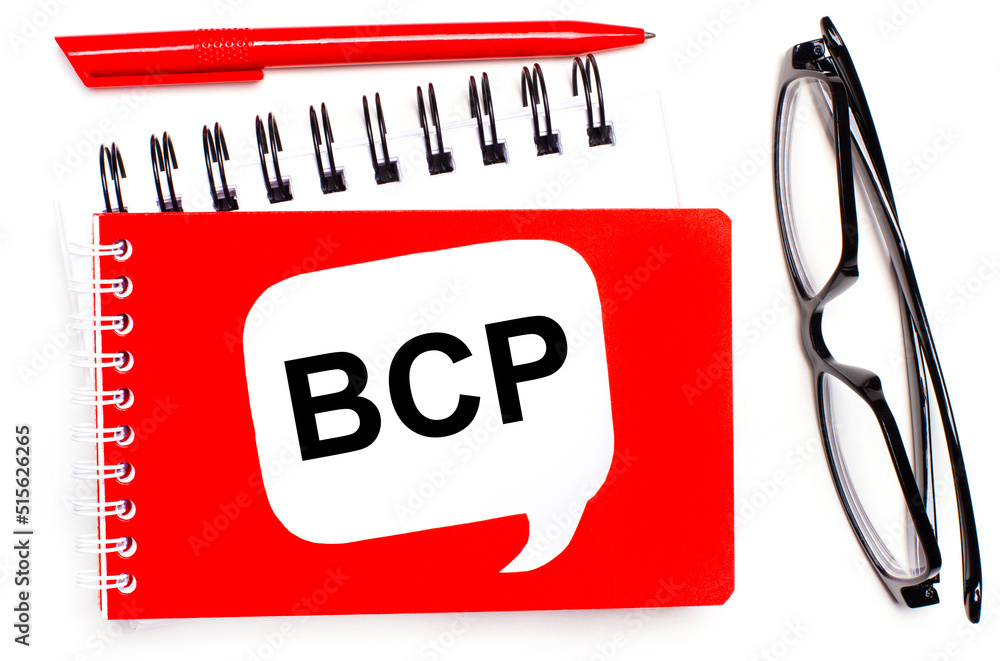 On a white background, white and red notepads, black glasses, a red pen and a white card with the text BCP Business Continuity Plan On a white background, white and red notepads, black glasses, a red pen and a white card with the text BCP Business Continuity Plan