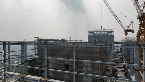 Building in construction in city, crane around. Drone aerial view. Construction site aerial view of downtown city Shanghai China.  Industry, business, house development concept concept b-roll footage.