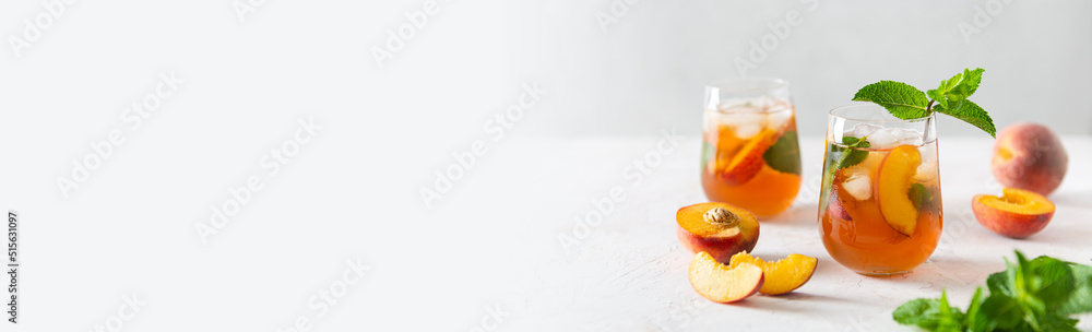 Summer cold peach fizz cocktail or iced tea with mint banner. Two glasses with peach lemonade on a white background. Summer refreshing drink offer. Bar, cafe web line. Copy space Summer cold peach fizz cocktail or iced tea with mint banner. Two glasses with peach lemonade on a white background. Summer refreshing drink offer. Bar, cafe web line. Copy space