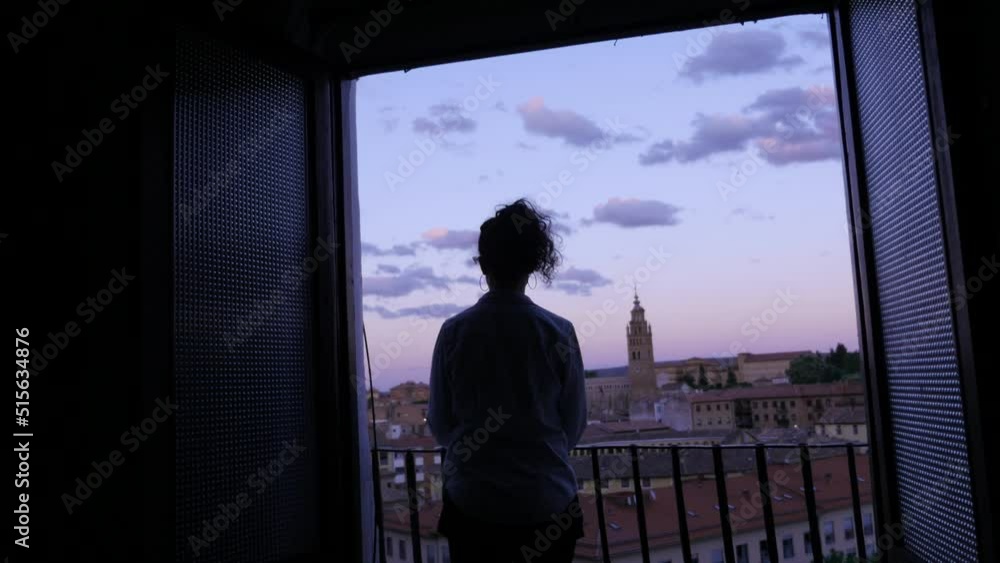 A woman on her balcony at sunset, in Paris A woman on her balcony at sunset, in Paris