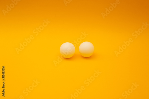 Table tennis ball on orange background