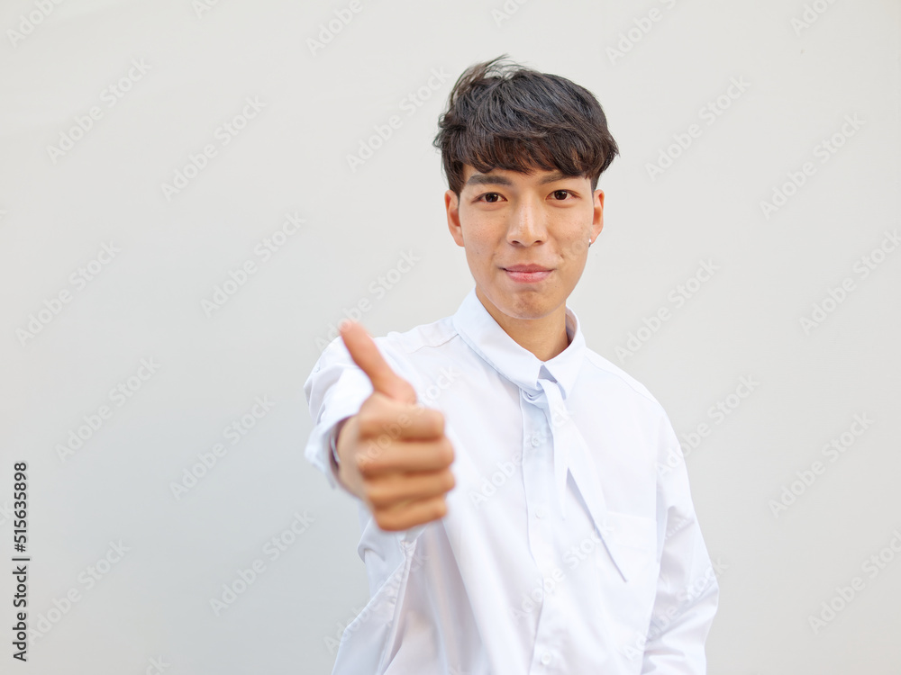 Portrait of Chinese young man with black hair in white shirt posing against white background, two thumbs up positive emotion, front view, focused on face. Portrait of Chinese young man with black hair in white shirt posing against white background, two thumbs up positive emotion, front view, focused on face.