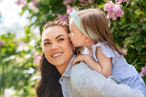 family, motherhood and people concept - happy mother with little daughter having fun at summer park or garden