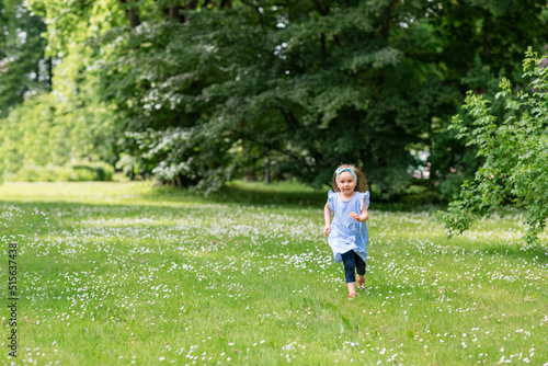 childhood, leisure and people concept - happy little girl running at park in summer