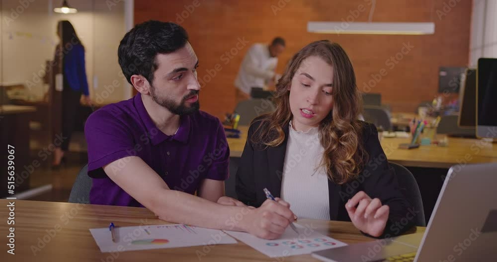 Two millennials employees at office meeting together. Female and male staff discussing work at office workplace Two millennials employees at office meeting together. Female and male staff discussing work at office workplace