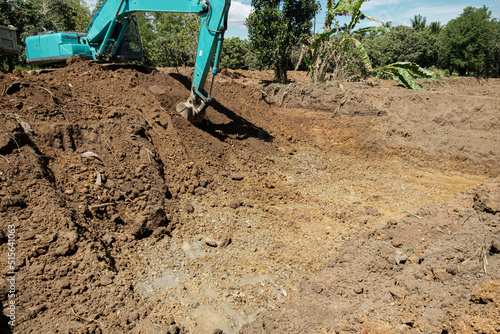Excavators are digging the soil ,dig a pond in the construction site location field