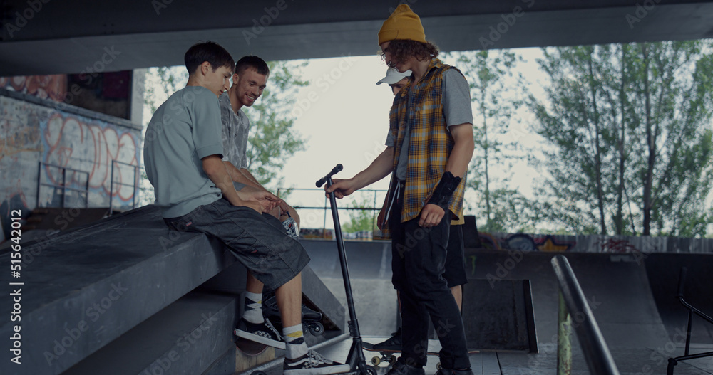 Young people spending time together outdoors. Hipster friends socializing. 
