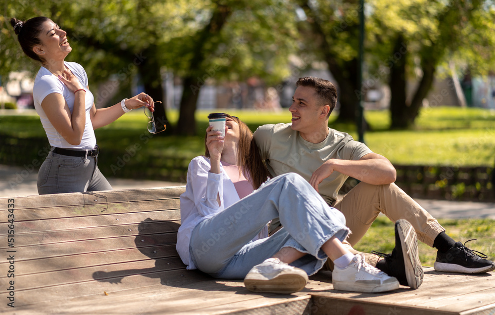 Group of happy friends sitting on bench in the street. Friendship concept Group of happy friends sitting on bench in the street. Friendship concept