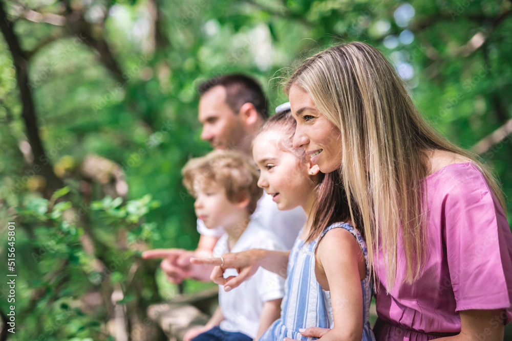 Father and mother with the son and daughters having fun outside in forest Father and mother with the son and daughters having fun outside in forest