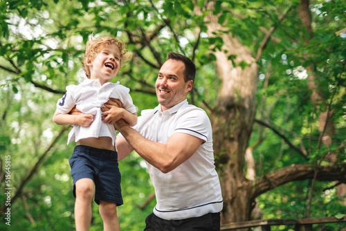 Father with his son having fun outside in forest