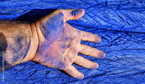 Closeup of a hand discolored blue by chalk paint