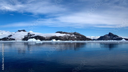 Icebergs floating at the base of a snow covered mountain  in the Southern Ocean  at Cierva Cove  Antarctica
