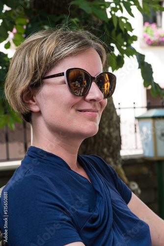 Portrait of a happy 30 yo white girl sitting on a terrace in summer photo