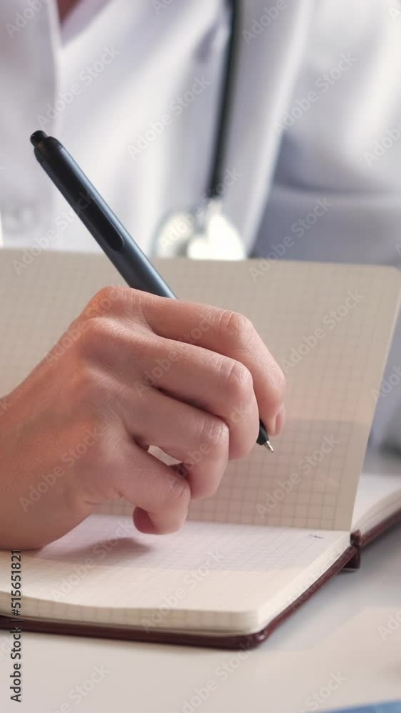 Vertical video. Medical research. Female doctor. Study education. Unrecognizable woman writing information in notebook sitting light room interior.