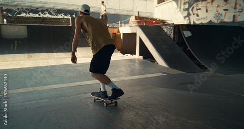 Active teenager skateboarding at skate park. Close up man riding on skate board 