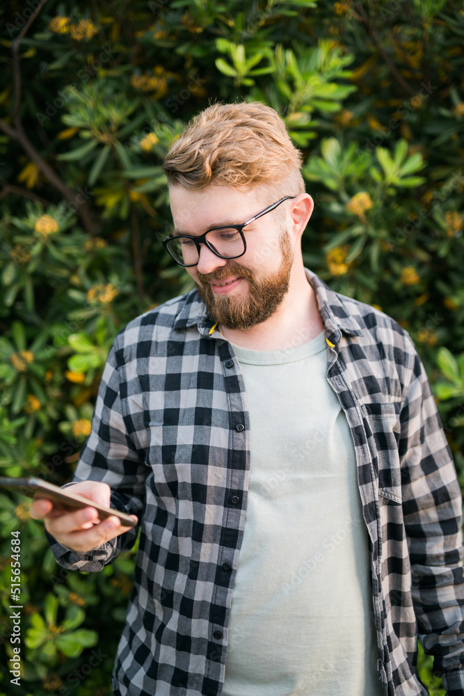 Attractive man wearing hat over green tree background - emotion and vacation travel holidays and social networks concept Attractive man wearing hat over green tree background - emotion and vacation travel holidays and social networks concept