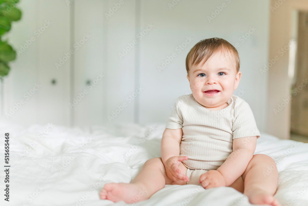 Adorable baby boy in white sunny bedroom in the morning at home Adorable baby boy in white sunny bedroom in the morning at home