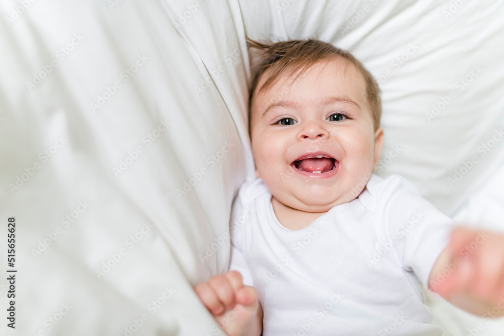 Adorable baby boy in white sunny bedroom in the morning at home Adorable baby boy in white sunny bedroom in the morning at home