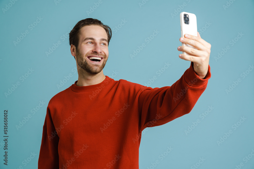 Young bristle man smiling and taking selfie on cellphone Young bristle man smiling and taking selfie on cellphone
