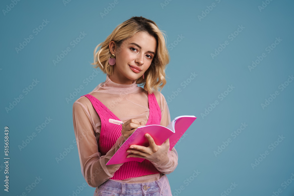 Young white woman writing down notes in exercise book Young white woman writing down notes in exercise book