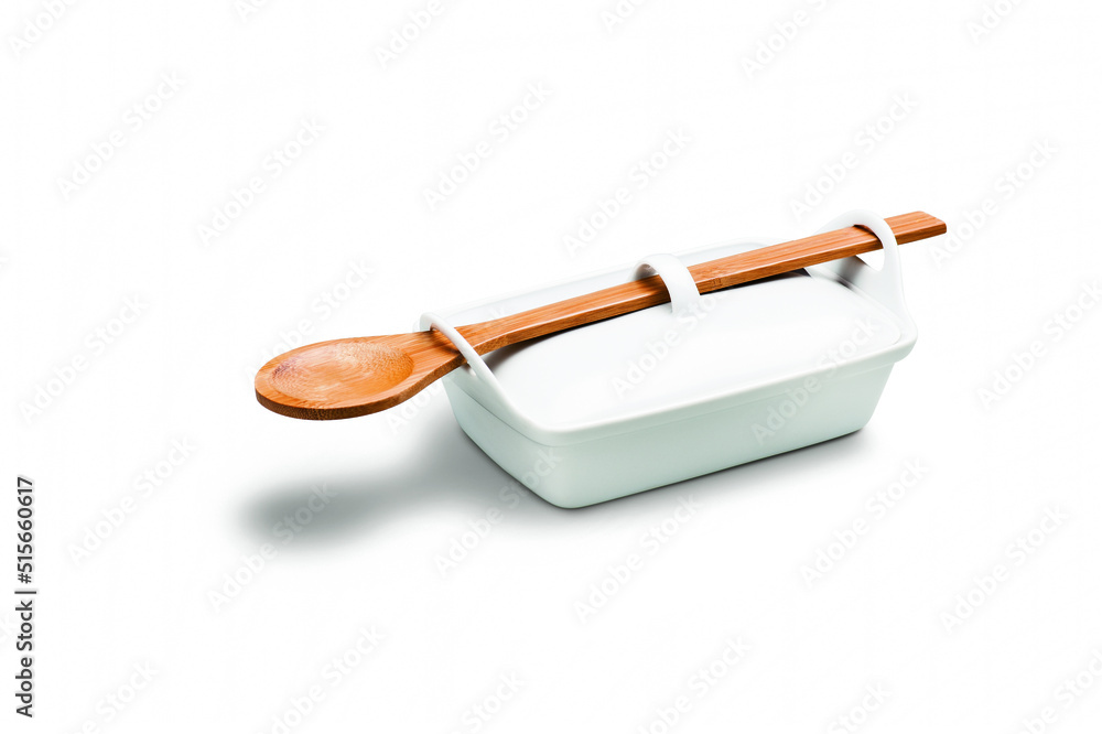 Rectangular white covered ceramic baker with wood spoon, isolated on white Rectangular white covered ceramic baker with wood spoon, isolated on white