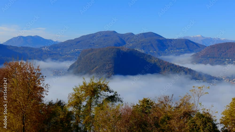 Panoramic View over Alpine Lake Lugano on the Border to Italy with Sea of Clouds and Mountain in a Sunny Autumn Day in Ticino, Switzerland. Panoramic View over Alpine Lake Lugano on the Border to Italy with Sea of Clouds and Mountain in a Sunny Autumn Day in Ticino, Switzerland.