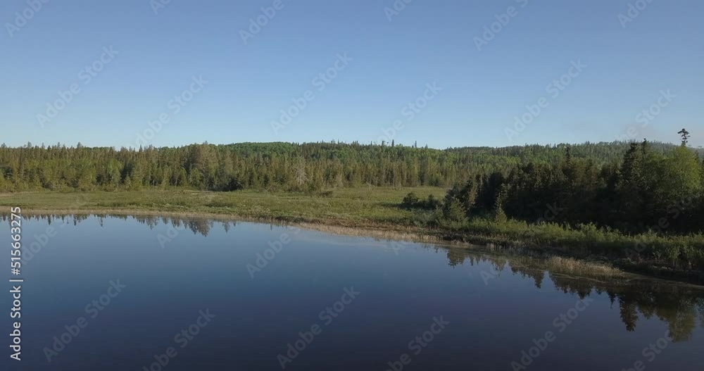 Aerial shot panning left over a calm watered lake facing a beautiful forest in northern Ontario Canada. Aerial shot panning left over a calm watered lake facing a beautiful forest in northern Ontario Canada.
