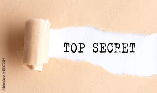 The text TOP SECRET appears on torn paper on white background.