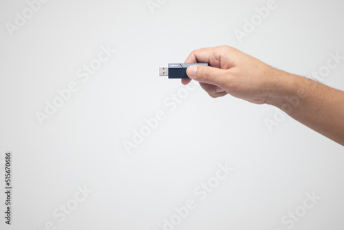 hand holding a flash drive on a white background