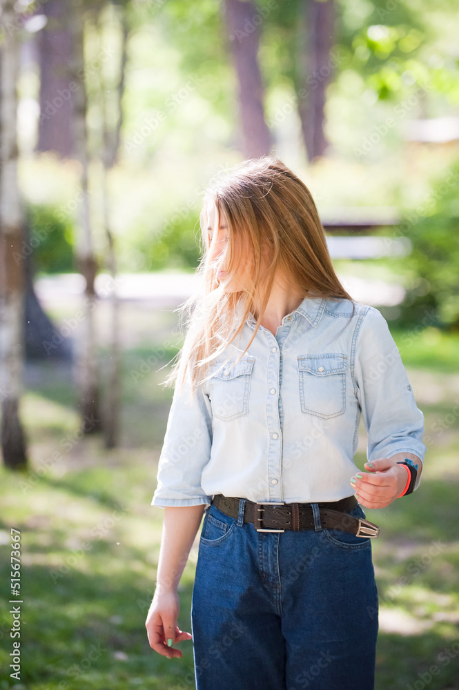 Young girl on a summer sunny day. Hair shines in the sun. Jeans styles. Young girl on a summer sunny day. Hair shines in the sun. Jeans styles.