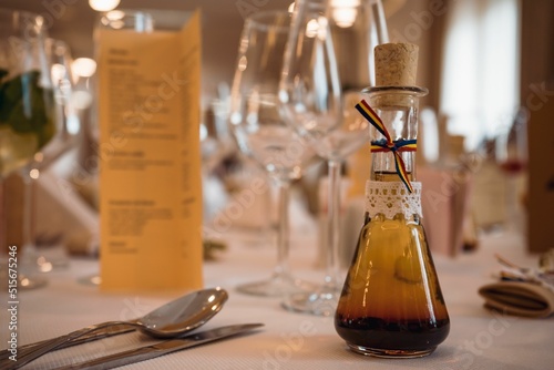 Closeup of a small bottle of alcohol with Romanian flag on the table as wedding gift