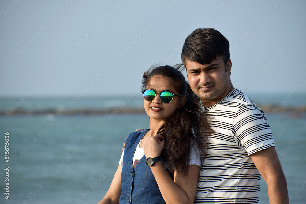 Portrait of young couple in the sea beach enjoying honeymoon time. Closeup of beautiful woman leaning on boyfriend.