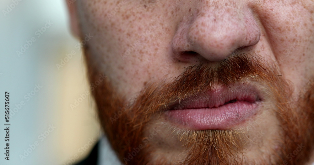 Upset man snarling close-up eyes and mouth. Redhead red beard grimacing angry person