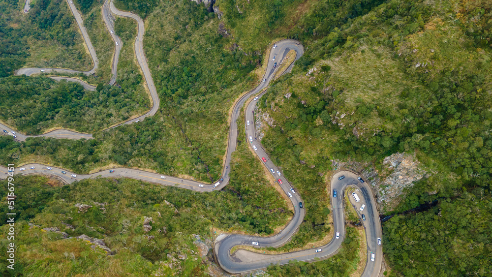Winding road in High mountain Pass Through Dense Green Pine Woods. Aerial View Winding road in High mountain Pass Through Dense Green Pine Woods. Aerial View