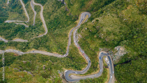Winding road in High mountain Pass Through Dense Green Pine Woods. Aerial View photo