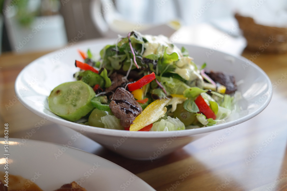 Salad is served on a white round plate. Salad is served on a white round plate.