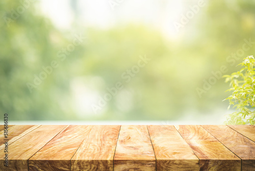 Selective focus.Empty wood table top on beautiful background of blur garden in the morning.