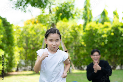 Asian family with both father, mother and daughter having fun in the garden of the house happily