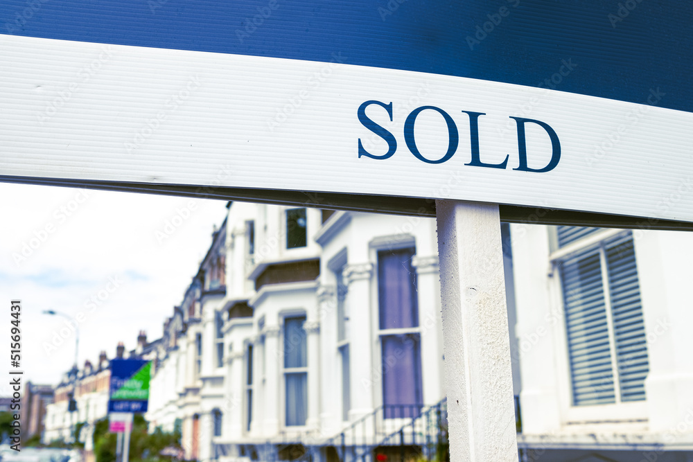 Obraz premium Estate agent SOLD sign on street of terraced houses