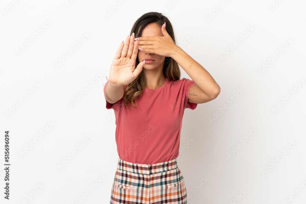 Young woman over isolated background making stop gesture and covering face Young woman over isolated background making stop gesture and covering face
