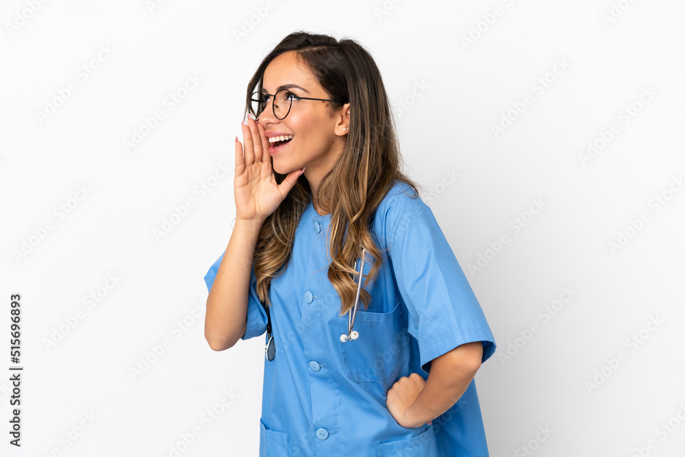 Young surgeon doctor woman over isolated white wall shouting with mouth wide open to the lateral Young surgeon doctor woman over isolated white wall shouting with mouth wide open to the lateral