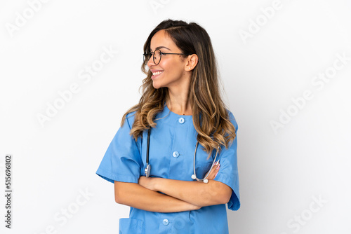 Young surgeon doctor woman over isolated white wall looking side