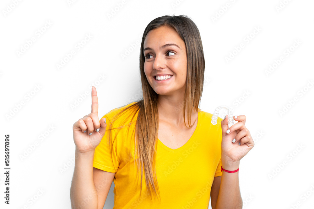 Young caucasian woman holding invisible braces isolated on white background intending to realizes the solution while lifting a finger up Young caucasian woman holding invisible braces isolated on white background intending to realizes the solution while lifting a finger up